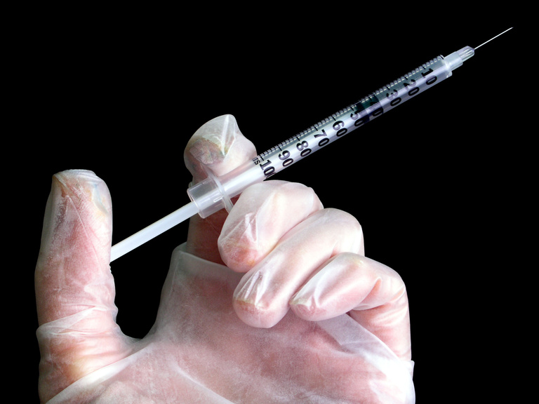 Syringe In Gloved Hand